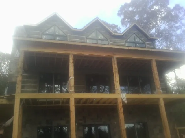 Dormers and porch framing on a large log home under construction — Roof Coating work by our crew in Tidioute