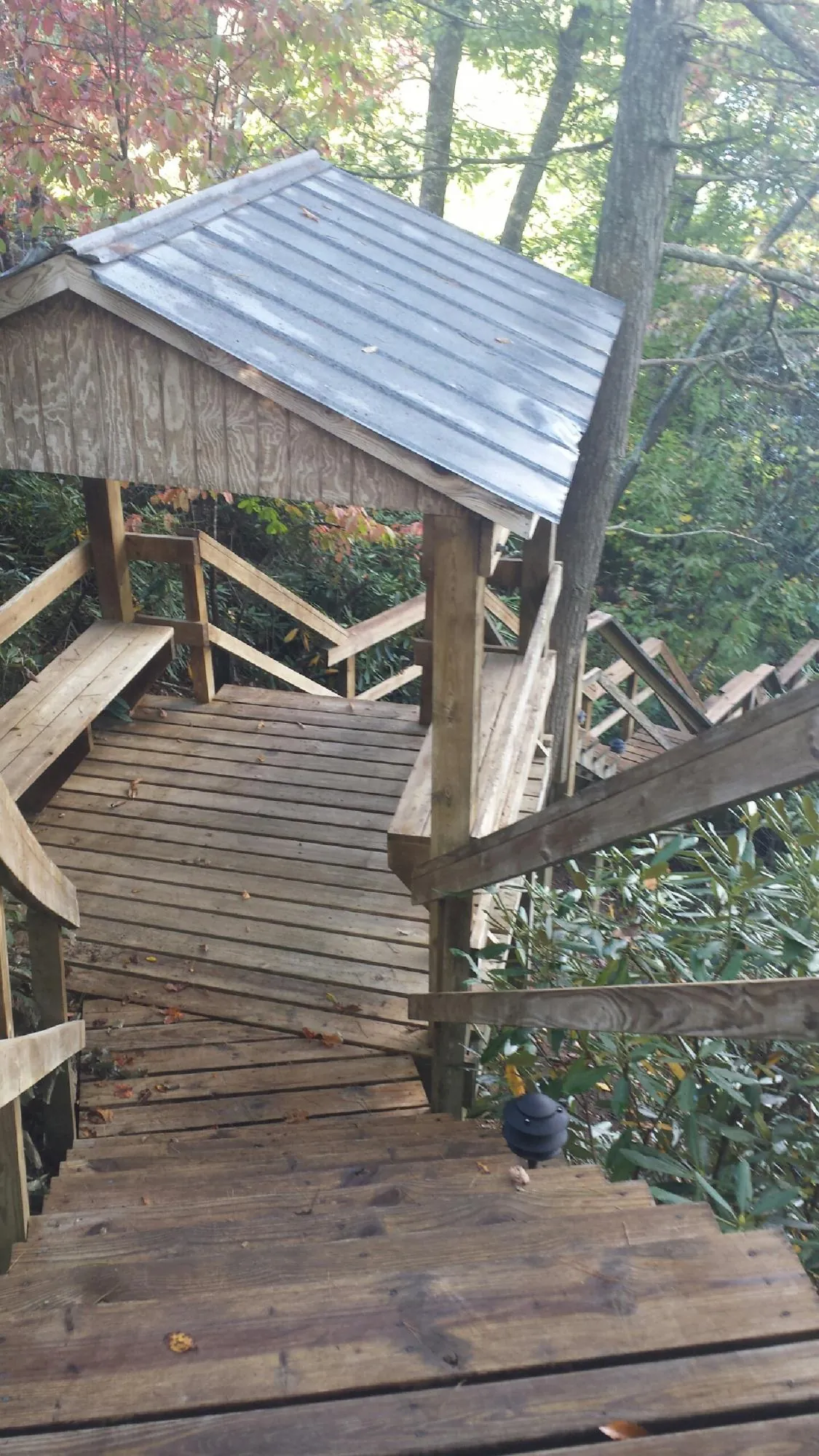 Metal roofed shelter over wooden steps on a wooded walkway — Skylight Repair & Installation work by our crew in Tidioute