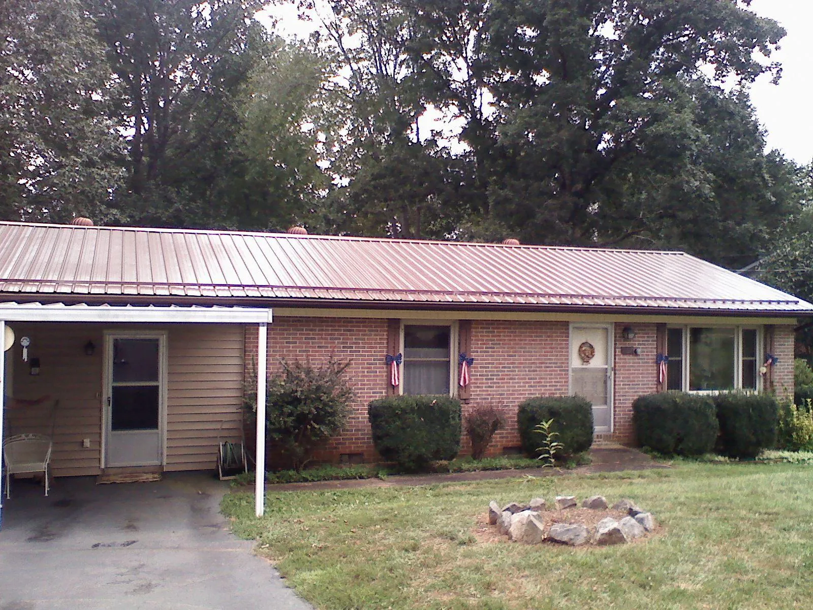 Bronze metal roof and carport on a brick ranch home — Roof Repair work by our crew in Tidioute