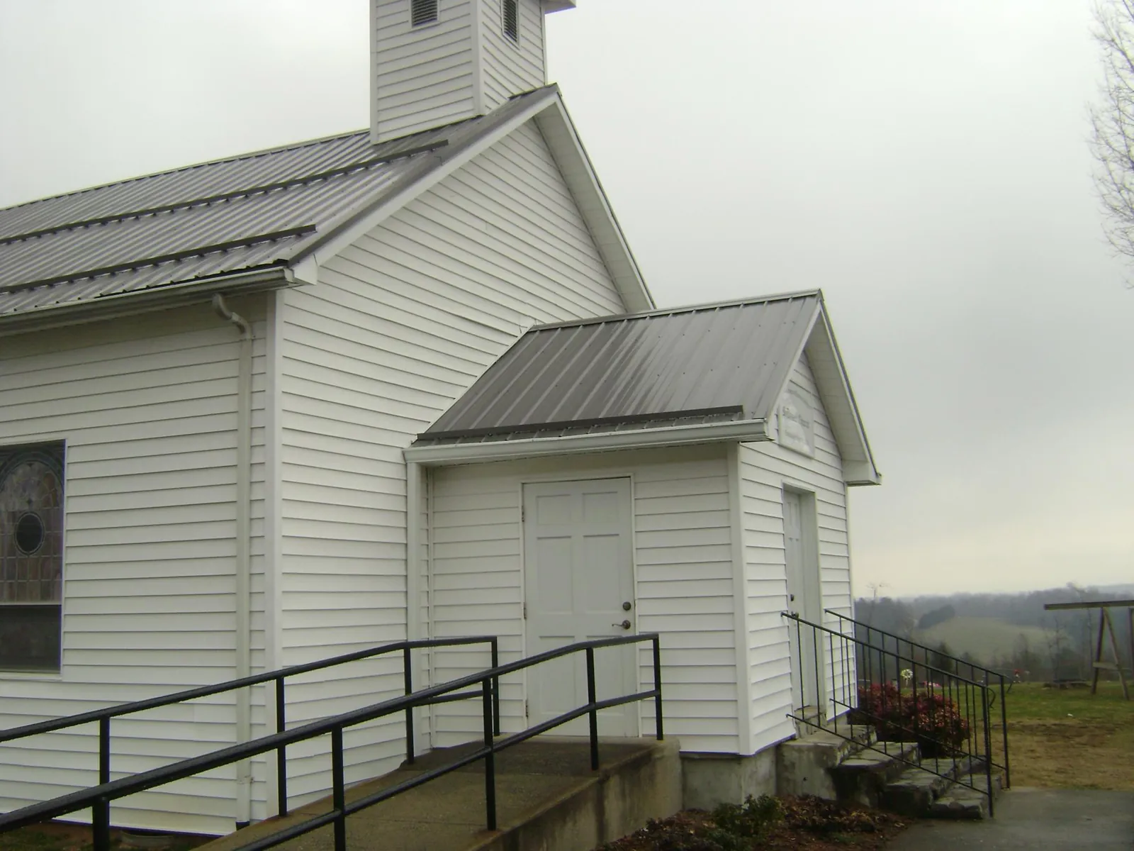 Gray metal roof on a white clapboard church with a steeple in Tidioute